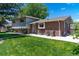 Exterior featuring brick and siding with lush green grass and manicured landscaping at 16225 W 74Th Dr, Arvada, CO 80007