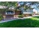 Charming brick and siding home with well-maintained lawn, stone pathway, and mature trees creating a beautiful, shaded yard at 16225 W 74Th Dr, Arvada, CO 80007