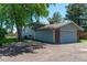 View of the home's exterior with a two-car garage and mature landscaping on a sunny day at 16225 W 74Th Dr, Arvada, CO 80007