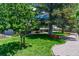 Lush green lawn and mature trees create a serene setting for this home, complemented by a stone pathway at 16225 W 74Th Dr, Arvada, CO 80007