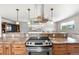 Open kitchen with granite countertops, stainless steel range hood, cooktop and breakfast bar area at 16225 W 74Th Dr, Arvada, CO 80007