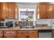 Bright kitchen with stainless steel appliances, granite countertops, wood cabinets and a view of the backyard at 16225 W 74Th Dr, Arvada, CO 80007