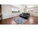Spacious living room with hardwood floors, leather seating, large windows, and lots of natural light at 16225 W 74Th Dr, Arvada, CO 80007