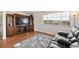 Inviting living room featuring hardwood floors, a large window, and a rustic entertainment center at 16225 W 74Th Dr, Arvada, CO 80007