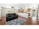 Open-concept living room with hardwood floors, a comfortable sofa, and a view into the kitchen at 16225 W 74Th Dr, Arvada, CO 80007