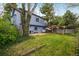 View of a grassy backyard with a swing set, patio, and a lush, verdant tree at 247 Regal St, Louisville, CO 80027
