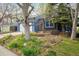 Inviting exterior of a blue home with well-kept landscaping and mature trees providing ample shade at 247 Regal St, Louisville, CO 80027