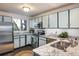 Modern kitchen with stainless steel appliances, granite countertops, and stylish blue and white cabinets at 247 Regal St, Louisville, CO 80027