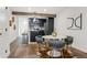 Modern dining area with stylish seating, wooden beam, and sleek black cabinets at 11842 W 14Th Ave, Lakewood, CO 80401