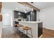Modern kitchen boasts stainless appliances, dark cabinetry, a breakfast bar with seating, and stylish pendant lighting at 11842 W 14Th Ave, Lakewood, CO 80401