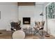 Cozy living room featuring brick fireplace, accent chairs, and a large window at 11842 W 14Th Ave, Lakewood, CO 80401