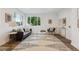 Bright living room features a black sofa, an area rug, and two large windows at 11842 W 14Th Ave, Lakewood, CO 80401