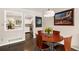 Cozy dining area with hardwood floors, modern lighting, and a view into the bright, updated kitchen at 6836 E Briarwood Dr, Centennial, CO 80112