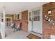 Inviting front porch features brick accents, cozy seating, and a charming welcome mat, enhancing curb appeal at 6836 E Briarwood Dr, Centennial, CO 80112