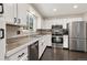 Well-lit kitchen with white cabinets, stainless steel appliances, and plenty of counter space for meal preparation at 6836 E Briarwood Dr, Centennial, CO 80112