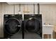 Laundry area with modern washer and dryer units and an adjacent utility sink at 6836 E Briarwood Dr, Centennial, CO 80112