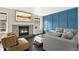 Stylish living room with a cozy fireplace, modern furnishings, and an eye-catching blue accent wall at 6836 E Briarwood Dr, Centennial, CO 80112