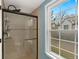 Shower features tiled walls, a glass door, and a bright window offering natural light and outside views at 6836 E Briarwood Dr, Centennial, CO 80112