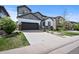 Charming two-story home with a well-kept lawn and a wide driveway leading to a two-car garage at 10934 Touchstone Loop, Parker, CO 80134
