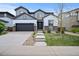 Charming two-story home featuring a gray garage door, modern siding, and a well-manicured front lawn at 10934 Touchstone Loop, Parker, CO 80134