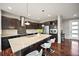 Modern kitchen with stainless steel appliances, granite countertops, dark wood cabinets, and a spacious island with seating at 10934 Touchstone Loop, Parker, CO 80134