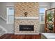 Cozy living room featuring a modern fireplace with stone surround, flanked by windows, and rich, dark floors at 10934 Touchstone Loop, Parker, CO 80134