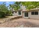 A spacious backyard featuring a stone patio, steps, lush landscaping and sliding glass doors into the home at 8441 S Timberwood St, Highlands Ranch, CO 80126