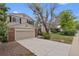 Traditional home with a two-car garage, brick accents, and mature trees in a landscaped yard at 8441 S Timberwood St, Highlands Ranch, CO 80126