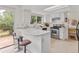 Bright kitchen features white cabinets, stainless steel appliances, peninsula with counter seating and sliding glass door at 8441 S Timberwood St, Highlands Ranch, CO 80126