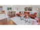 Open-concept living space with hardwood floors, a modern sofa, and a dining area with seating at 8441 S Timberwood St, Highlands Ranch, CO 80126
