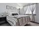 Bright bedroom with a white metal bed frame, soft gray carpet, and decorative wall art at 8293 S Reed St, Littleton, CO 80128