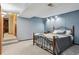 Basement bedroom, light blue walls, carpeted, and large, neutral bed frame at 8293 S Reed St, Littleton, CO 80128