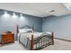 Bedroom with soft lighting, dark metal bed frame, neutral color scheme, and gray carpet at 8293 S Reed St, Littleton, CO 80128