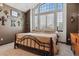 Bedroom featuring an arched window, unique wall decor, and neutral tones at 8293 S Reed St, Littleton, CO 80128