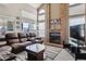 Cozy living room with a brick fireplace, large windows, and comfortable leather seating at 8293 S Reed St, Littleton, CO 80128