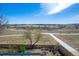 A back yard with a patio set and a sidewalk leading towards a trail in an open field under a bright, sunny sky at 5667 W 109Th Cir, Westminster, CO 80020