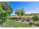 Landscaped backyard features a small fire pit area with mature trees, flowers, and open space behind the property at 5667 W 109Th Cir, Westminster, CO 80020