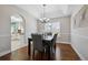 Well-lit dining room featuring dark wood floors, a chandelier, and view into kitchen and backyard at 5667 W 109Th Cir, Westminster, CO 80020