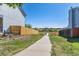 A concrete walking path that leads to the open field with some houses along its sides and a sunny sky at 5667 W 109Th Cir, Westminster, CO 80020
