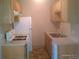 A galley kitchen features light wood cabinets and white appliances at 10762 E Exposition Ave. Ave # 137, Aurora, CO 80012