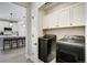 Laundry room and kitchen featuring modern appliances, lighting and eating bar at 16277 Talons Bluff Ln, Monument, CO 80132