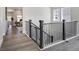 Stylish staircase with dark wood railing and light gray hardwood flooring at 16277 Talons Bluff Ln, Monument, CO 80132