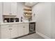 Finished basement wet bar boasts white cabinetry, sink, wine fridge, and open shelving at 16277 Talons Bluff Ln, Monument, CO 80132