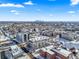 Wide aerial view of a snowy urban neighborhood with city skyline in the distance at 4383 Tennyson St # 1A, Denver, CO 80212