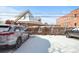 Snow-covered parking lot with cars parked near a church and building at 4383 Tennyson St # 1A, Denver, CO 80212