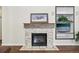 Fireplace featuring a rustic mantel and brick surround, with built-in shelving and a decorative picture above at 2420 E 127Th Ave, Thornton, CO 80241