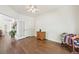 Bright living room with hardwood floors, ceiling fan, and French doors to the office at 2420 E 127Th Ave, Thornton, CO 80241