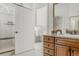 Bathroom with wooden cabinets, marble counters, an open door, and a view into the bright primary bedroom at 869 Bluestem Ln, Louisville, CO 80027