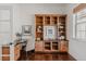 Well-lit home office with custom built-ins, dark countertops, and hardwood floors at 869 Bluestem Ln, Louisville, CO 80027