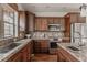 Elegant kitchen featuring granite countertops, a stainless steel oven, and dark wood cabinets at 869 Bluestem Ln, Louisville, CO 80027